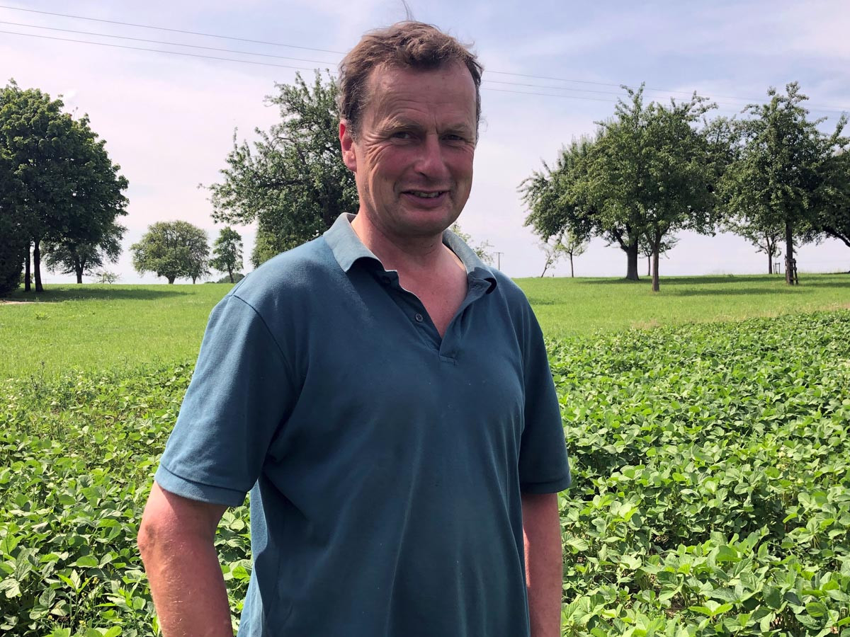 Demeter-Landwirt Dietmar Lober vor seinem Feld mit Sojapflanzen.